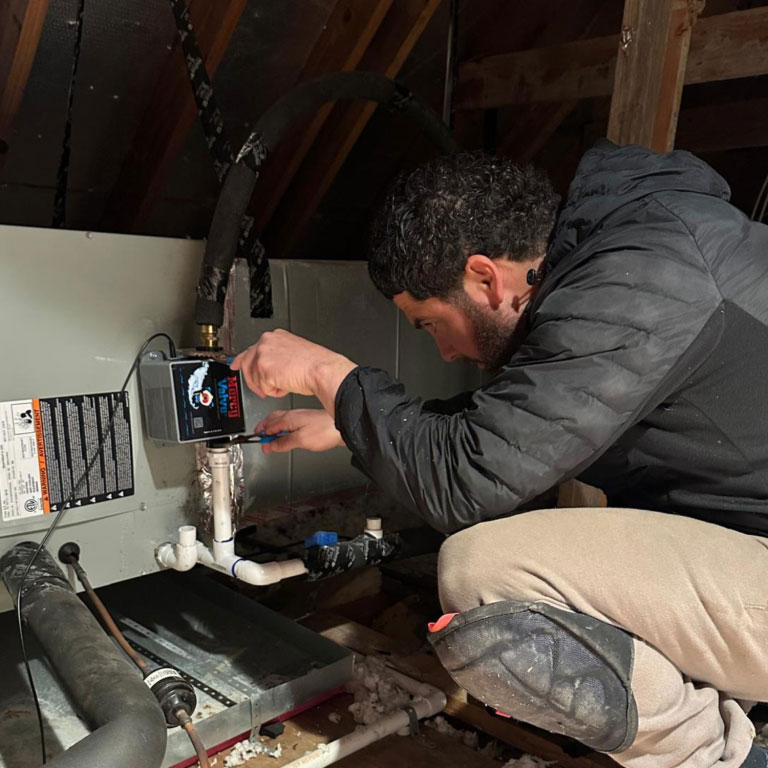 John installing Mercy Valve on AC drain line in attic